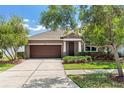 Well-maintained single-Gathering home with a two-car garage, manicured landscaping, and a covered entryway at 9031 Sienna Moss Ln, Riverview, FL 33578