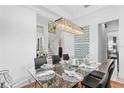 Elegant dining area with a crystal chandelier, glass table, and view of the staircase at 916 Seagrape Dr, Ruskin, FL 33570
