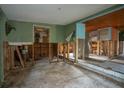 Open-concept living space featuring damaged walls and flooring awaiting full renovation at 9810 Parsons St, Tampa, FL 33615