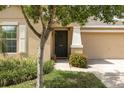 Inviting entryway of home with a well-manicured lawn and a cozy front porch featuring colorful flowers at 10036 Crested Fringe Dr, Riverview, FL 33578