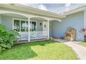 Inviting front porch with decorative railing, stone water feature, and well-manicured lawn at 1101 Mclean St, Dunedin, FL 34698