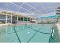 Sparkling screened-in pool with clear blue water, patio furniture, and ample space for relaxation at 1101 Mclean St, Dunedin, FL 34698