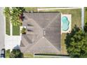 Aerial view of a home showcasing the roof, backyard pool, and surrounding neighborhood at 11845 Newberry Grove Loop, Riverview, FL 33579