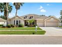 Inviting single-Gathering home with a lush green lawn, mature landscaping, and a double car garage at 11845 Newberry Grove Loop, Riverview, FL 33579