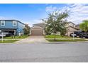 Well-manicured lawn and brick driveway leading up to this lovely home with a two car garage and mature landscaping at 11871 Crestridge Loop, Trinity, FL 34655