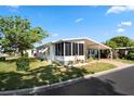 Inviting home featuring a screen room, covered carport, and meticulously landscaped grounds at 12501 Ulmerton Rd # 89, Largo, FL 33774