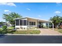 Cozy home features a screen room, carport, and well-maintained landscaping for a relaxing outdoor experience at 12501 Ulmerton Rd # 89, Largo, FL 33774