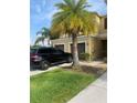 Townhouse featuring an attached garage and a lush green lawn, complemented by a modern black vehicle at 12952 Utopia Gardens Way, Riverview, FL 33579