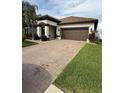 Beautifully landscaped home with a two-car garage and a paved driveway at 13172 Green Violet Dr, Riverview, FL 33579