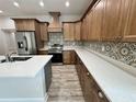 A well appointed kitchen featuring wooden cabinets, quartz countertops, stainless steel appliances, and modern backsplash at 13532 14Th St, Dade City, FL 33525