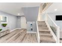 Cozy entryway featuring wood floors, stairs with glass railing, and beach themed wall decor at 1390 Gulf Blvd # Ph-5, Clearwater, FL 33767