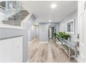 Bright entryway with wood floors, glass railed staircase, and sliding mirrored closet at 1390 Gulf Blvd # Ph-5, Clearwater, FL 33767