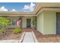 Inviting front porch with decorative ironwork, American flag, and a neatly landscaped walkway at 1450 Palmetto St, Clearwater, FL 33755