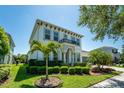Beautiful two-story home with a manicured lawn, lush landscaping, and a charming front balcony at 15422 Starling Crossing Dr, Lithia, FL 33547