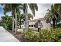 Attractive condo entrance with tropical landscaping and a welcoming sign for Oceanfront 1912 at 1912 Gulf Blvd # 305, Indian Rocks Beach, FL 33785