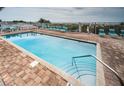 Inviting community pool with brick pavers and lounge chairs, perfect for relaxation near the beach at 1912 Gulf Blvd # 305, Indian Rocks Beach, FL 33785