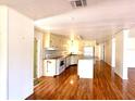 Bright kitchen featuring wood floors, center island, and white cabinets at 210 N Saint Thomas Cir, Apollo Beach, FL 33572