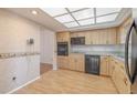A sunlit kitchen features oak cabinets, black appliances, and a tile backsplash, exuding a cozy and functional charm at 2436 Rhodesian Dr # 24, Clearwater, FL 33763