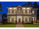 Exterior shot of a charming two-story home featuring a welcoming front porch and balcony at dusk at 2714 W Jetton Ave, Tampa, FL 33629