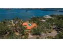 Aerial view of coastal home with a pool, surrounded by mature trees and backing onto the water at 2834 Pelham N Rd, St Petersburg, FL 33710
