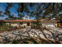 Charming single-story home featuring a red tile roof, a well-manicured lawn and mature trees at 2834 Pelham N Rd, St Petersburg, FL 33710