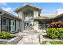 Elegant front entrance featuring stone accents, a stylish door, and lush landscaping along the walkway at 3342 Waterford Dr, Clearwater, FL 33761
