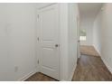 Bright hallway with hardwood flooring and white doors, offering a clean and modern aesthetic at 34847 Daisy Meadow Loop, Zephyrhills, FL 33541
