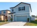 Inviting two-story home boasting blue siding, a tidy lawn, and convenient attached garage at 34866 Daisy Meadow Loop, Zephyrhills, FL 33541