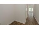 Bright hallway with hardwood floors, white walls, and modern lighting leading into the home at 34866 Daisy Meadow Loop, Zephyrhills, FL 33541