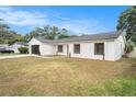 Charming single-story home with a modern white exterior, black trim and garage door, and a well-manicured lawn at 3707 Orangepointe Rd, Valrico, FL 33596