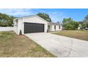 Charming single-story home with a modern white exterior, black trim and garage door, and a well-manicured lawn at 3707 Orangepointe Rd, Valrico, FL 33596