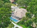 Aerial view showcasing a screened-in pool, white fencing, and lush surrounding greenery for backyard privacy at 4101 Brooke Dr, Valrico, FL 33594
