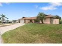 Lovely single-story home featuring a terracotta roof and an expansive green lawn with a palm tree at 5008 Southshore Dr, New Port Richey, FL 34652