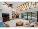 Cozy living room with a stone fireplace, vaulted ceilings, and sliding glass doors to the pool area at 6514 Sunhigh Dr, New Port Richey, FL 34655