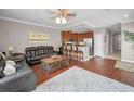 Open concept living room featuring wood floors, ceiling fan, and breakfast bar access to kitchen at 6902 47Th N Ln, Pinellas Park, FL 33781