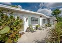 Inviting front porch with seating, surrounded by lush landscaping and charming green shutters at 7108 N Howard Ave, Tampa, FL 33604