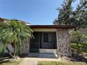 Charming single-story home with a brick facade, a screened-in porch, and mature landscaping at 7360 Ulmerton Rd # 20F, Largo, FL 33771