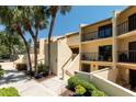 Exterior of condo building with palm trees, stairs to units, and maintained grounds at 7500 Sunshine Skyway S Ln # 201, St Petersburg, FL 33711