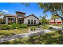 Well-maintained home showcasing lush landscaping, a tile roof, and a welcoming driveway at 8434 Dunham Station Dr, Tampa, FL 33647