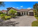Beautiful single-story home featuring a three-car garage, manicured landscaping, and a paved driveway at 8434 Dunham Station Dr, Tampa, FL 33647
