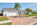 Bright single-story home with a brick driveway, a two-car garage and well-maintained landscaping at 8529 Regal Ln, Hudson, FL 34667