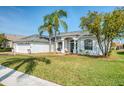 Charming home with a well-manicured lawn, mature trees, and an inviting two-car garage at 8529 Regal Ln, Hudson, FL 34667