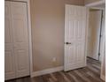 Neutral bedroom showcasing fresh paint, new flooring, and white trim, with closet and ensuite access at 10116 N Highland Ave, Tampa, FL 33612