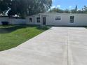 Charming single-story home with a well-manicured lawn and a spacious concrete driveway at 10116 N Highland Ave, Tampa, FL 33612