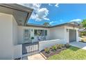 Inviting front porch with seating and a well-maintained garden, perfect for enjoying sunny days at 110 8Th St, Belleair Beach, FL 33786