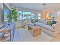 Cozy living room bathed in natural light with a plush sofa, stylish rug, and scenic outdoor views at 110 8Th St, Belleair Beach, FL 33786