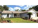 Well-manicured front lawn and mature landscaping enhance this one-story home's curb appeal at 11303 Hollyglen Dr, Tampa, FL 33624