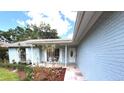 Inviting covered front porch perfect for relaxing, featuring elegant brickwork and lush landscaping at 11303 Hollyglen Dr, Tampa, FL 33624
