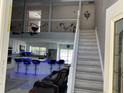 Open-concept living space with high ceilings, tile floors, a modern kitchen, and stairs to the second floor at 11727 Spanish Lake Dr, Tampa, FL 33635