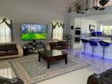 Bright living room featuring modern furniture, high ceilings, tile floors, and seamless open concept to kitchen at 11727 Spanish Lake Dr, Tampa, FL 33635